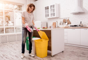 Frau sortiert Müll in einer modernen Küche