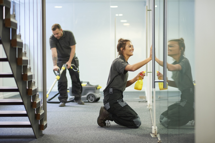 Reinigungsteam bei der Arbeit – Gründliche Glas- und Bodenreinigung in einem modernen Gebäude.